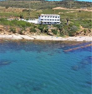 een wit gebouw op een heuvel naast een strand bij Hotel Boutique Milla de Plata in Torreguadiaro