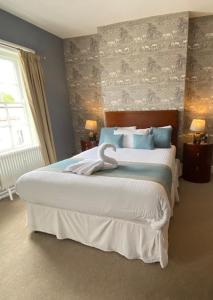 a bedroom with a large white bed with blue pillows at The Great Western Hotel in Taunton