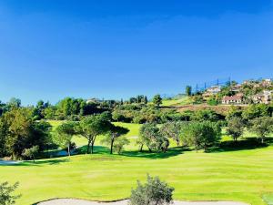- Vistas a un campo de golf con árboles y casas en Buenavista Golf La Torre, en Málaga
