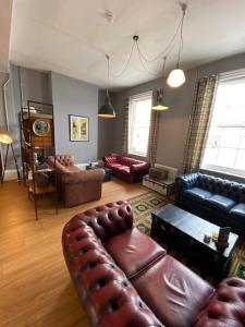 a living room with a leather couch and chairs at The Great Western Hotel in Taunton