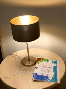 una lampada seduta sopra un tavolo con un libro di Villa Vera a Ora/Auer