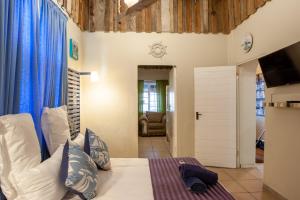 ケープタウンにあるStrand Family studio en-suite 6 sleeper Kitchenette Helderberg CTのベッドルーム1室(青いカーテン付きのベッド1台付)