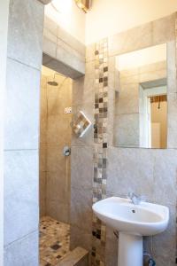 a bathroom with a sink and a shower with a mirror at Strand Family studio en-suite 6 sleeper Kitchenette Helderberg CT in Cape Town