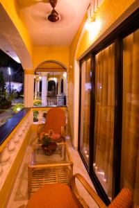 a room with a balcony with chairs and a table at Primavera Holiday Homes-GOA-CANDOLIM BEACH WITHIN 300 MTRS-GOAN FAMILY HOSPITALITY in Candolim
