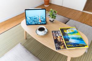 a coffee table with a laptop and a cup of coffee at stay's ジローズ浄心 601号 名古屋 民泊 駅近 in Nagoya