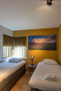 德科赫Zilte Bries的一间卧室，墙上有两张床和一幅画