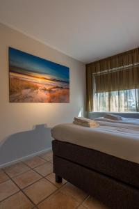 德科赫Zilte Bries的卧室里有一张床，墙上挂着一幅画