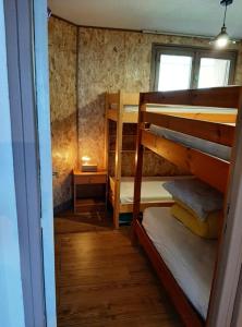 une chambre avec deux lits superposés et une fenêtre dans l'établissement LE COSY aux pieds des pistes appartement avec balcon PLEIN CENTRE, à Orcières