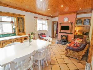 Collooney的住宿－Clodagh's Cottage，厨房以及带桌椅的起居室。