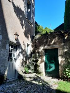 ein Gebäude mit einer grünen Tür neben einem Gebäude in der Unterkunft Suite 2 - Les Grands Degrés Saint Louis in Blois