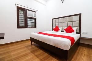 a bedroom with a large bed with red pillows at Super OYO Taj Royal in Tājganj
