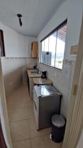 a small kitchen with a stove and a window at Pousada Mar Dos Anjos in Arraial do Cabo