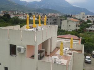 uma varanda com cadeiras e guarda-sóis amarelos num edifício em Apartments Bojanic em Bar