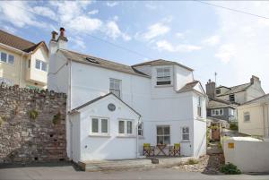 a white house in the middle of a street at Birdcage Cottage, Kingsand in Kingsand