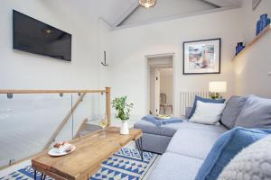 a living room with a couch and a table at Birdcage Cottage, Kingsand in Kingsand