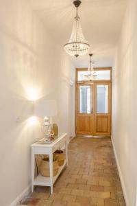 a hallway with a white table and a chandelier at Apartment No4 in Stralsund