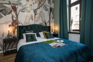 Un dormitorio con una cama con un edredón azul. en Boho Lofts - LoftAffair, en Cracovia