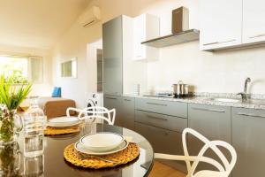 uma cozinha com uma mesa e cadeiras numa cozinha em Villa Alessandri - Direttamente sulla Spiaggia em Albinia