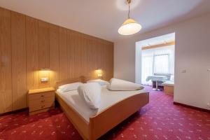 Hotel Stilfserhof في ستلفيو: غرفة نوم بسرير مع سجادة حمراء