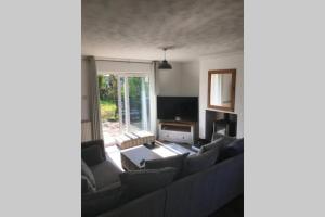 a living room with a couch and a table at Birchwood Cottage with hot tub in Valley