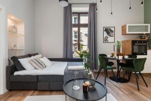 una sala de estar con un sofá y una mesa en Boho Lofts - LoftAffair, en Cracovia