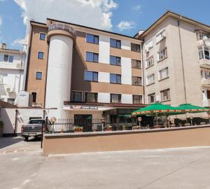 a large building with a building with green umbrellas at Hotel Terra in Gorna Oryakhovitsa