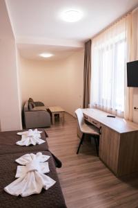 a hotel room with two beds and a desk at Hotel Terra in Gorna Oryakhovitsa