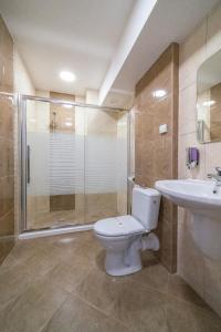 a bathroom with a toilet and a shower and a sink at Hotel Terra in Gorna Oryakhovitsa