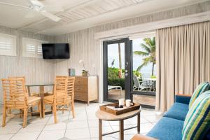 a living room with a couch and a table and a dining room at High Noon Beach Resort in Fort Lauderdale