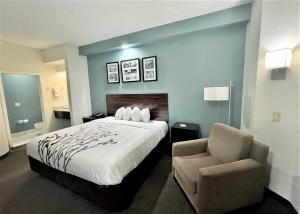 Habitación de hotel con cama y silla en Caper House Inn, en Augusta