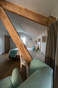 B&B De Fruithoeve في Hoeselt: غرفة نوم بسرير واريكة في غرفة