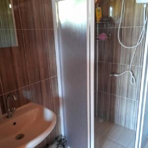 a shower with a glass door next to a sink at Caunos bungalow in Muğla