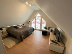 Schlafzimmer im Dachgeschoss mit einem Bett und einem Fenster in der Unterkunft Anker 39 in Plau am See