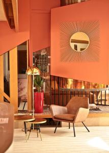 - un salon avec une chaise et un miroir dans l'établissement Logis Hostellerie D'Aussois, à Semur-en-Auxois