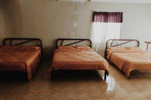 two beds sitting in a room with a window at Aqua Blue Wave Port Dickson Home Villa in Port Dickson +26 photos