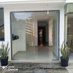 une porte en verre menant à un couloir avec deux plantes en pot dans l'établissement 6 Park Retreat, à Mombasa