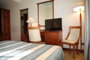 a hotel room with two beds and a television at Hotel Lugano in Marghera