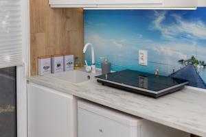 a kitchen counter with a sink and a view of the ocean at Rooms of Poland (500m od Suntago) in Krzyżówka