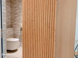a bathroom with a toilet and a wooden wall at Seeing Inn in Taitung City