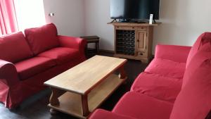 uma sala de estar com um sofá e duas cadeiras e uma mesa em le sanglier em Bertogne