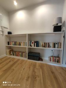 a room with white book shelves filled with books at Un balcón sobre el Rio Sella in Ribadesella