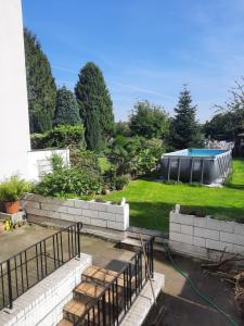 a backyard with a swimming pool and a hose at Joys Ferienwohnung in Oberhausen