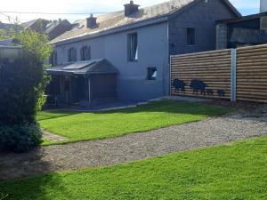 une maison avec une cour avec de l'herbe verte dans l'établissement le sanglier, à Bertogne