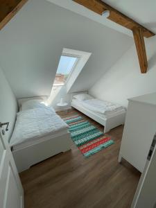 a attic room with two beds and a rug at Ferienvermietung Klakus - a60263 in Fehmarn