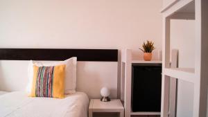 a bedroom with a bed with a black and white headboard at Breathe In in Zambujeira do Mar