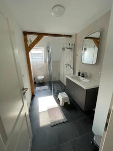 een badkamer met een bad, een wastafel en een spiegel bij Ferienvermietung Klakus - a60263 in Fehmarn
