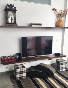 a living room with a flat screen tv on a wall at Casa dos Retratos Faro in Faro