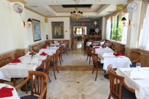 un ristorante con tavoli e sedie bianchi e un lampadario di Hotel Chateaubleau a Miami