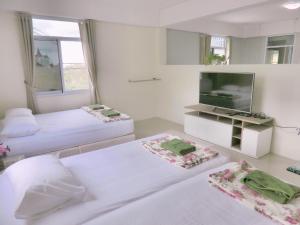 a bedroom with two beds and a flat screen tv at Green View 104 Khao Kho in Khao Kho
