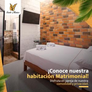 Habitación con cama y pared de ladrillo en HOSPEDAJE SANTA MONICA, en Tarapoto